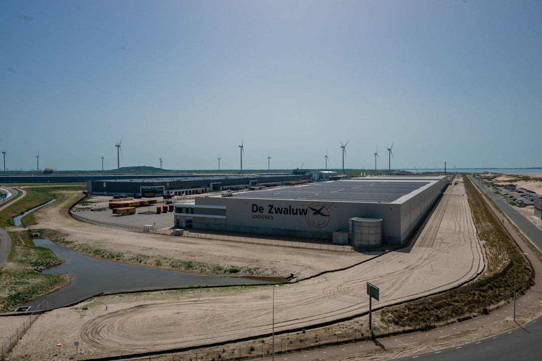 Edificio industriale con pannelli solari e turbine eoliche, immagine illustrativa dell'energia sostenibile