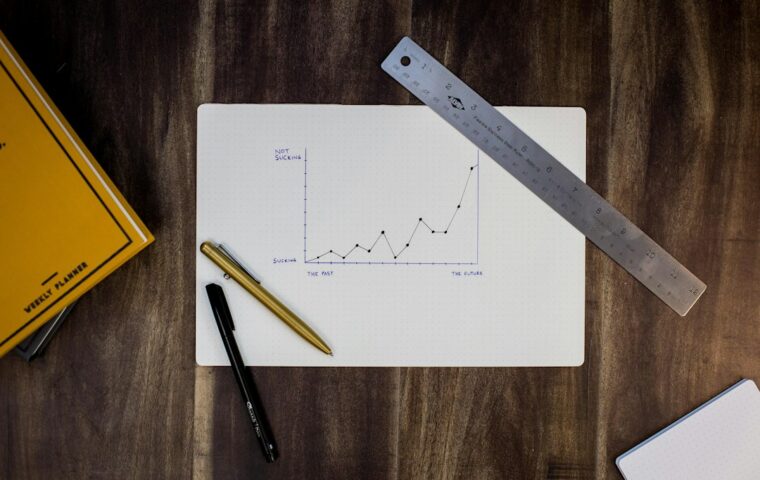 Grafici e appunti di analisi statistica su una scrivania, immagine illustrativa; fotografia di Isaac Smith su Unsplash