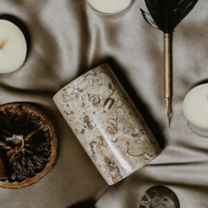 Composizione illustrativa con candele e penna d'oca. Foto di Emily Underworld su Unsplash; non documenta il rito che sarà eseguito su ordinazione.