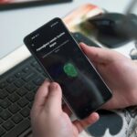 Mano che utilizza un sensore di impronte su smartphone, immagine illustrativa della privacy e delle scelte digitali. Foto: Onur Binay / Unsplash.