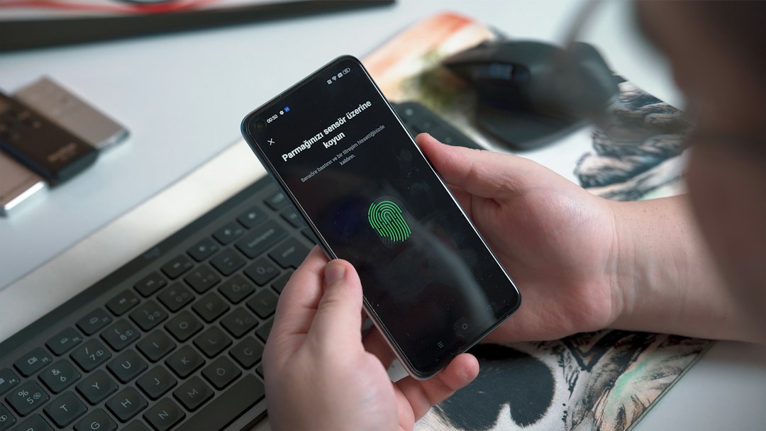 Mano che utilizza un sensore di impronte su smartphone, immagine illustrativa della privacy e delle scelte digitali. Foto: Onur Binay / Unsplash.